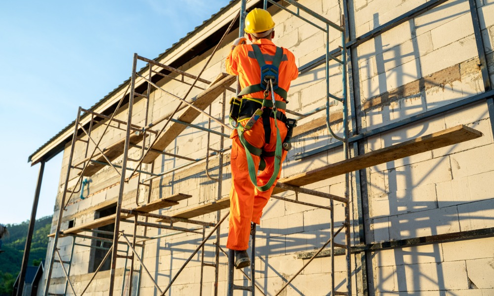 Construction worker inspecting scaffolding fall protection systems