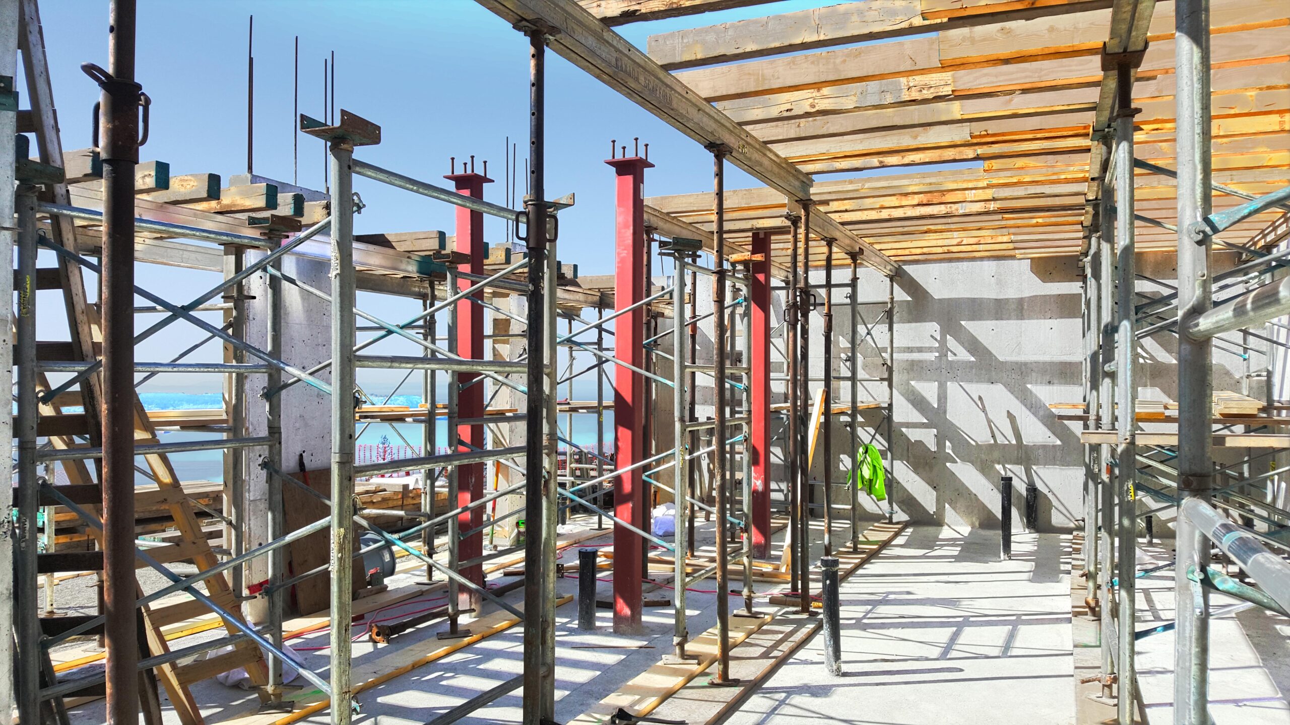 Workers inspecting formwork and shoring on a construction site